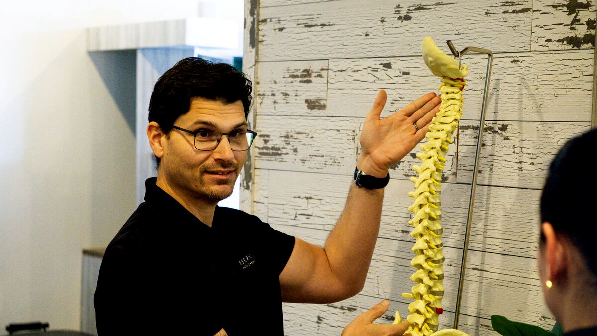 Dr. Martin explaining findings on the spine model