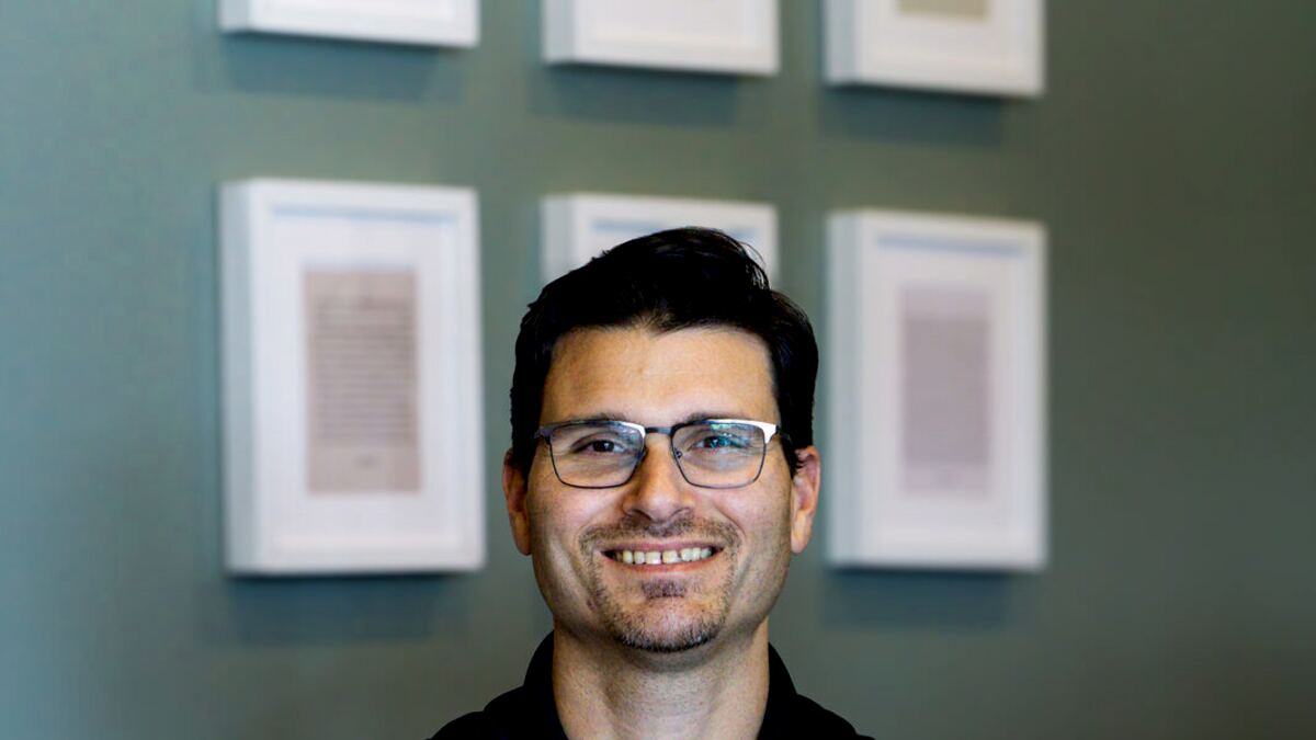 Dr. Martin in front of the framed certificates, arms crossed